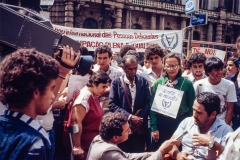 Grupo de pessoas em frente ao Teatro Municipal de SP com o cartaz do "Ano Internacional das Pessoas Deficientes". 7/4/1981. Coleção Romeu Sassaki.