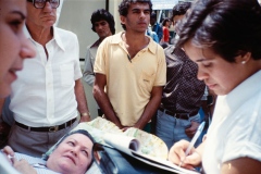 Grupo de pessoas em frente ao Teatro Municipal de SP com o cartaz do "Ano Internacional das Pessoas Deficientes". 7/4/1981. Coleção Romeu Sassaki.