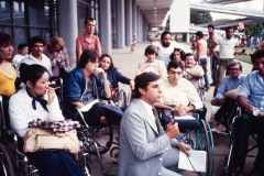 Grupo de pessoas em evento no prédio da Bienal no Parque do Ibirapuera. Coleção Romeu Sassaki.